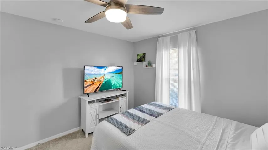 Bedroom with light colored carpet and ceiling fan