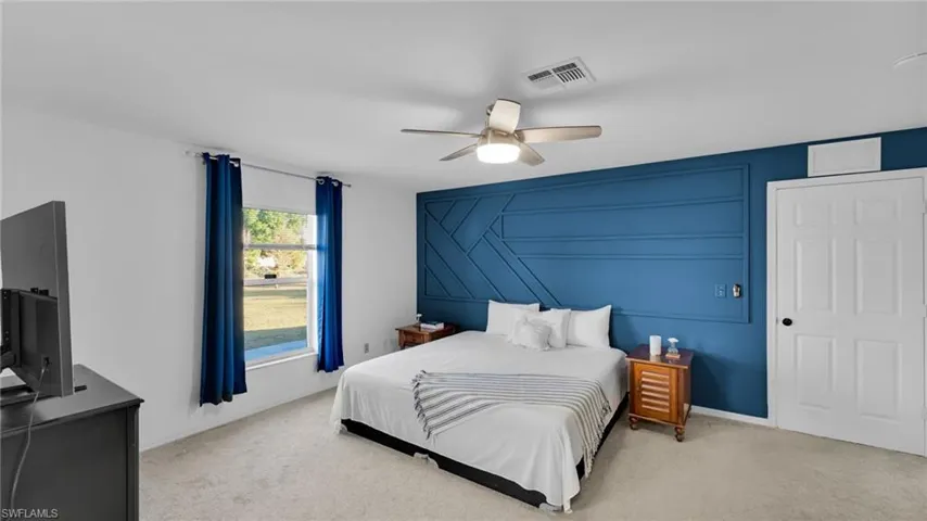 Carpeted bedroom featuring ceiling fan