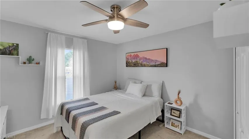 Bedroom with ceiling fan and light colored carpet