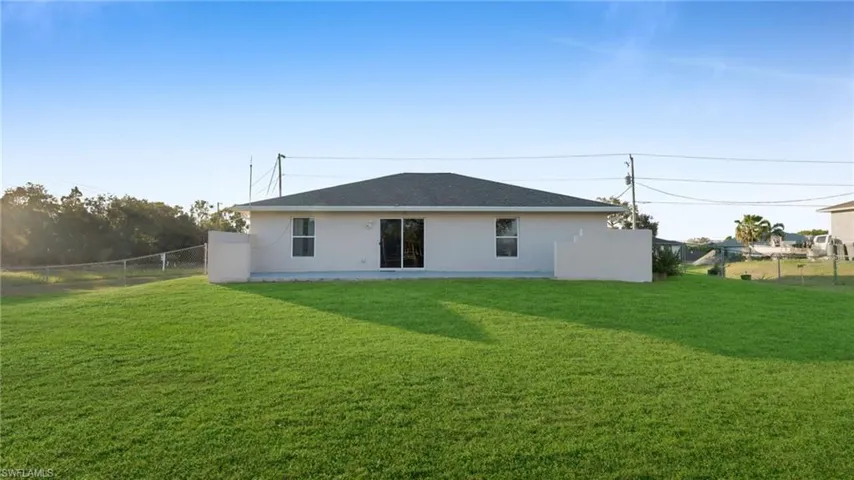 Rear view of property with a lawn