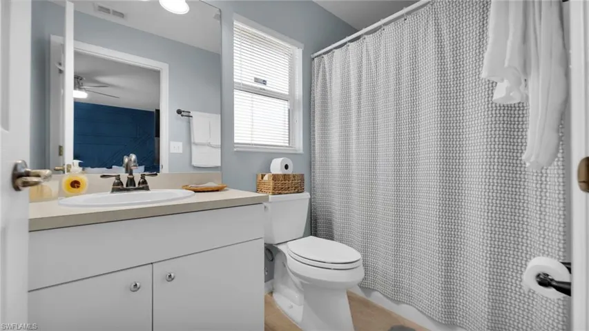 Bathroom featuring vanity, ceiling fan, and toilet