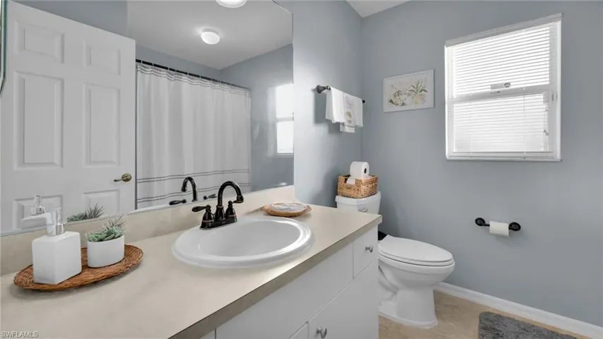Bathroom featuring vanity, tile patterned floors, and toilet
