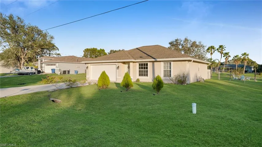 Ranch-style house with a garage and a front lawn