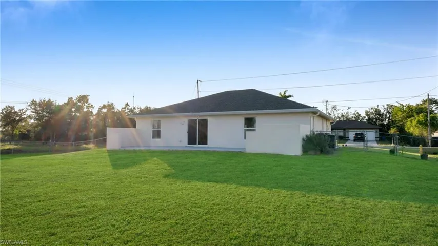 Rear view of house featuring a yard