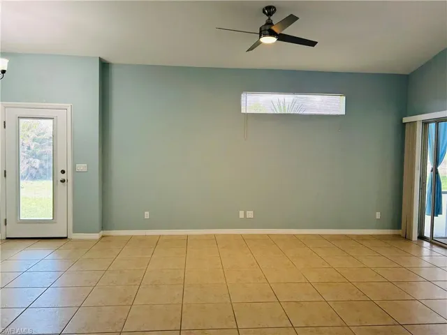 Unfurnished Living room with plenty of natural light, a ceiling fan, and light tile patterned floors
