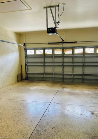Garage with a textured wall and a garage door opener