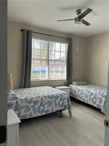 Bedroom with light wood-type flooring and ceiling fan.  Furniture can stay with the home or owner is happy to remove.