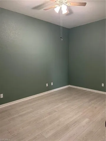 Spare room with a ceiling fan, a textured ceiling, and light wood-style flooring