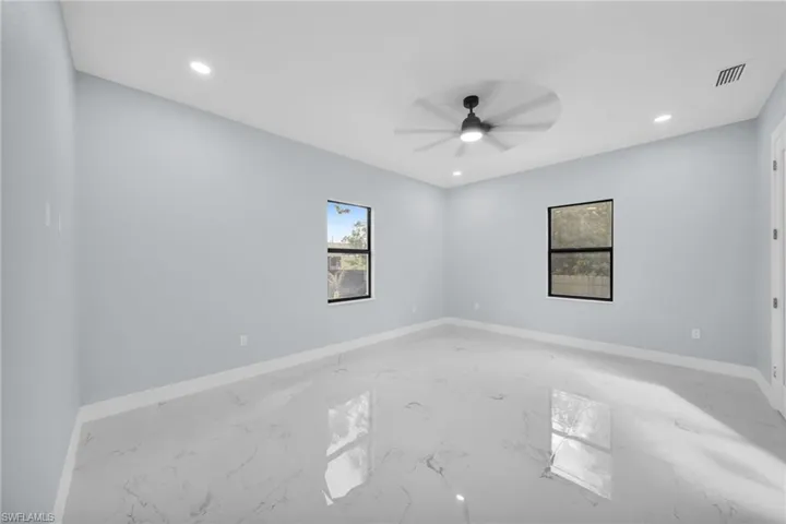 Empty room featuring recessed lighting, a ceiling fan, and light marble finish flooring