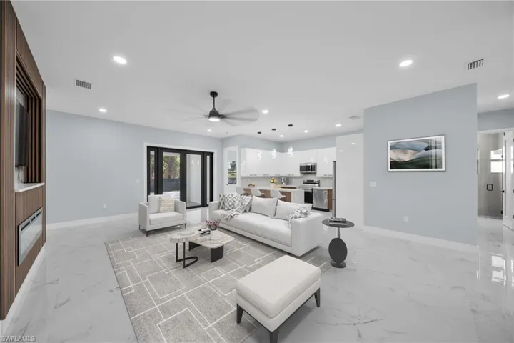 Living room with recessed lighting, ceiling fan, and light marble finish flooring