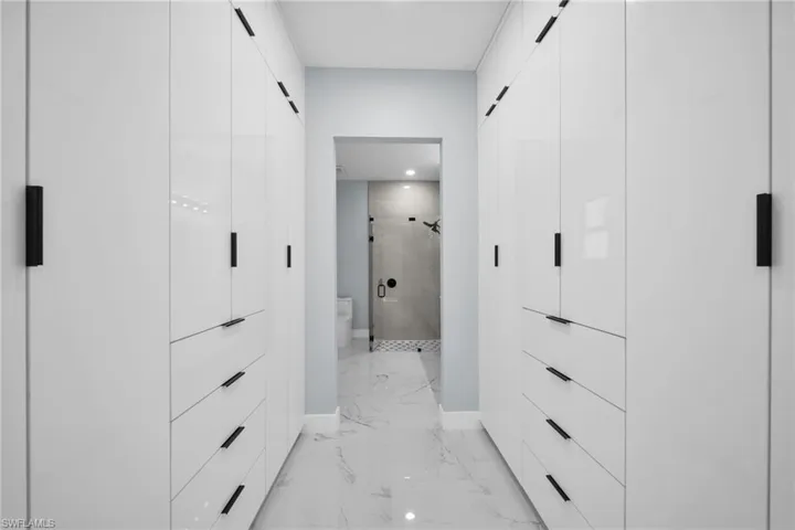 Walk in closet with light marble finish flooring