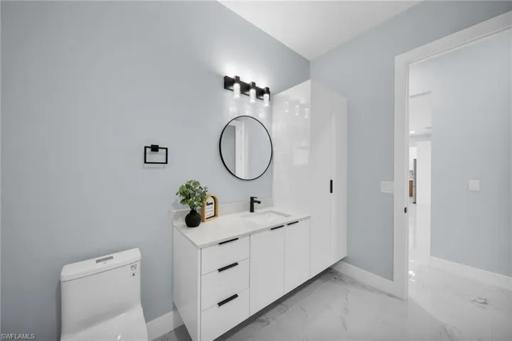 Bathroom featuring vanity and light marble finish flooring