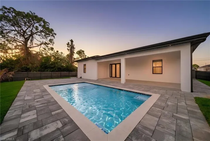 Rear view of property with a patio area, a fenced backyard, and stucco siding