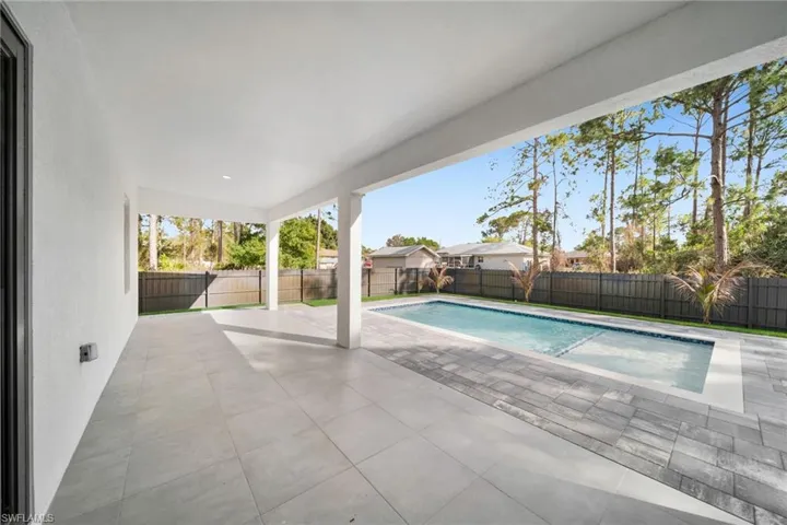 View of pool with patio surround and a fenced backyard