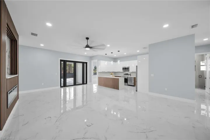 Unfurnished living room featuring recessed lighting, ceiling fan, and light marble finish flooring