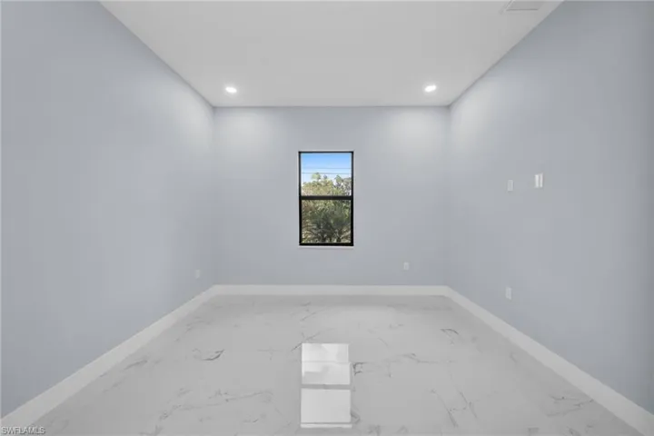 Spare room featuring recessed lighting and light marble finish flooring