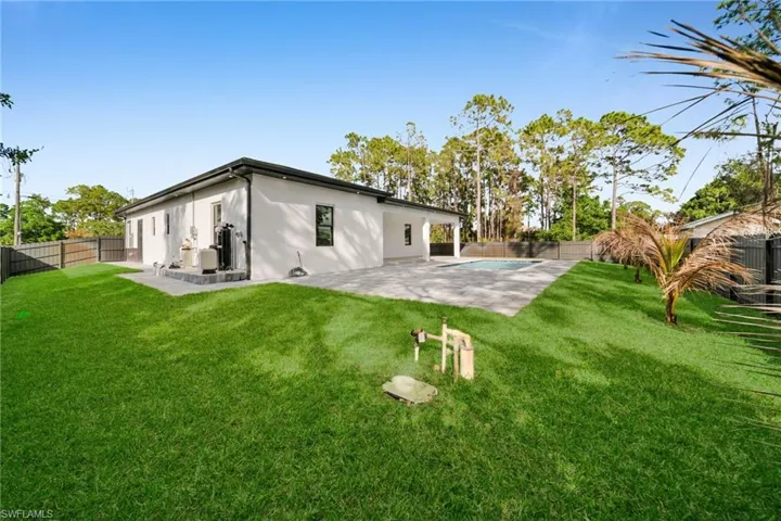 Rear view of property featuring a fenced backyard, a patio area, and stucco siding