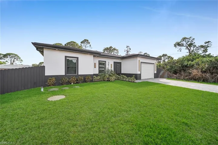 Prairie-style house with concrete driveway, stucco siding, and a garage