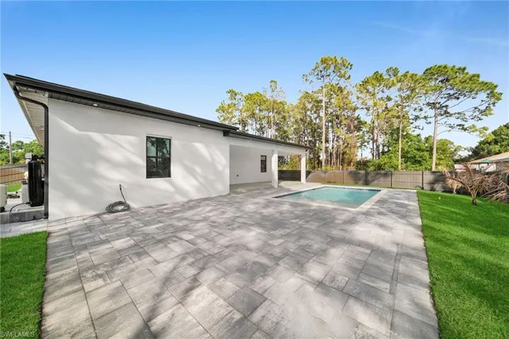View of swimming pool with patio surround and a fenced backyard