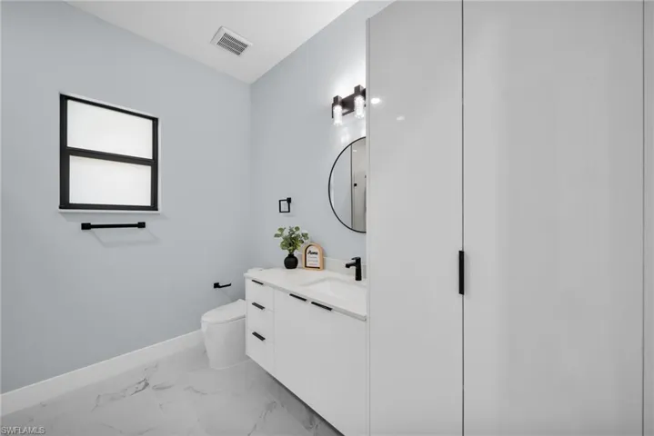 Bathroom with vanity and light marble finish flooring