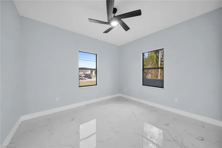 Spare room featuring a ceiling fan and light marble finish flooring