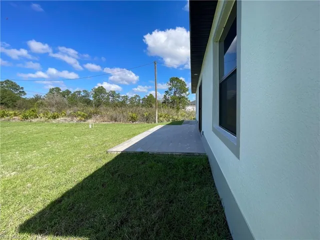 View of grassy yard featuring a patio