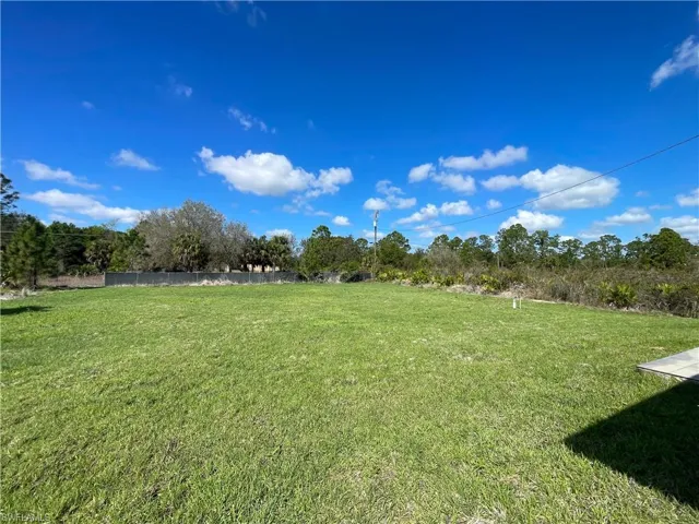 View of green lawn with view of wooded area