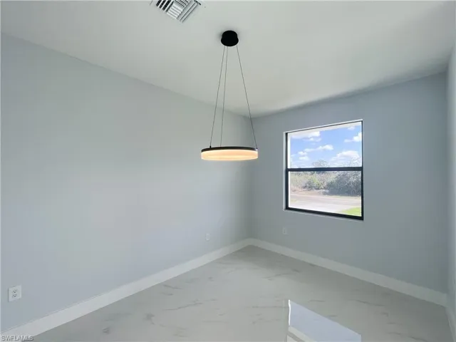 Unfurnished room featuring baseboards and light marble finish flooring
