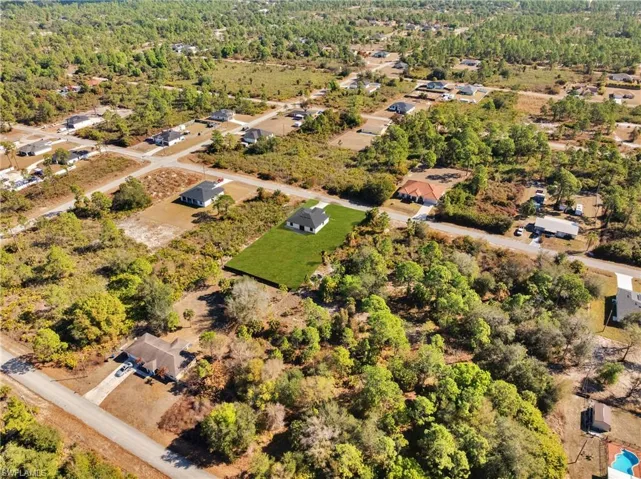 Aerial overview of property's location featuring a forest and nearby suburban area