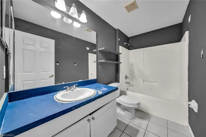 Bathroom with vanity, shower / bathtub combination, and light tile patterned floors