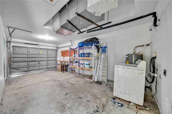 Garage featuring washer / clothes dryer and water heater