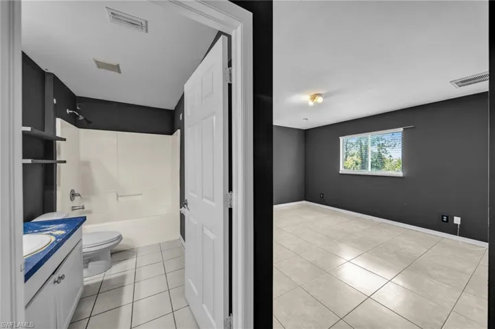 Full bath featuring vanity, light tile patterned floors, and shower / bathtub combination