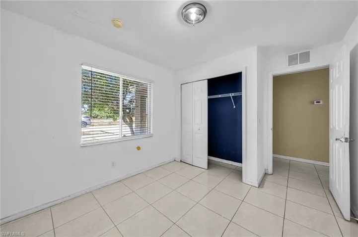 Unfurnished bedroom with a closet and light tile patterned flooring