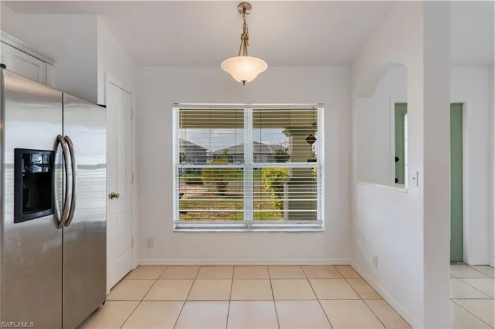 Open concept dining area with tiled flooring and a brushed nickel ceiling fixture