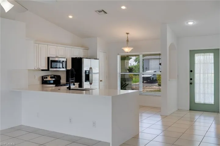 Kitchen featuring a peninsula with a white countertop, white cabinetry, and stainless-steel appliances