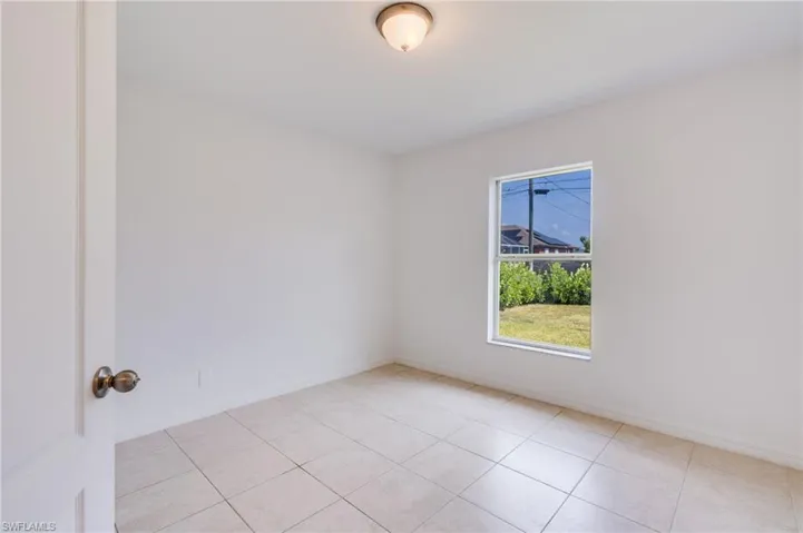 Light-filled room featuring neutral wall finishes and large format tile flooring