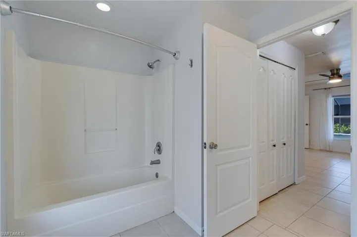 Tub and shower combination with a single-handle faucet and integrated shelving