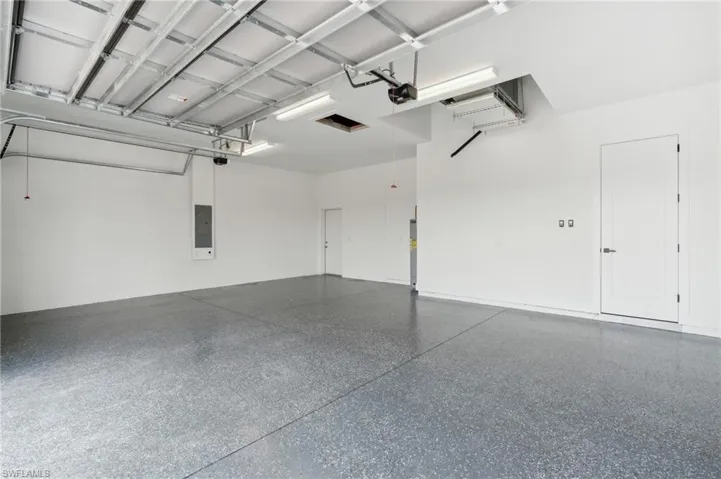 Garage featuring a garage door opener and electric panel