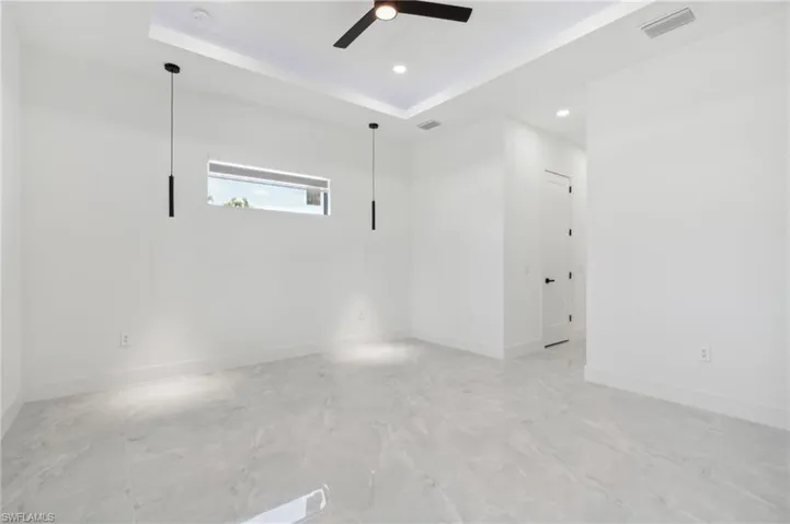 Unfurnished room featuring a tray ceiling and ceiling fan