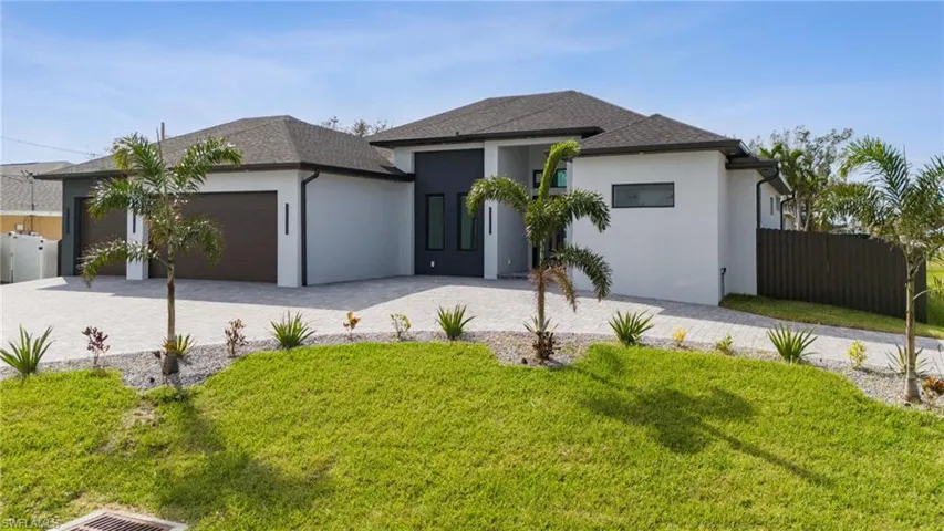 View of front of home with a front lawn and a garage