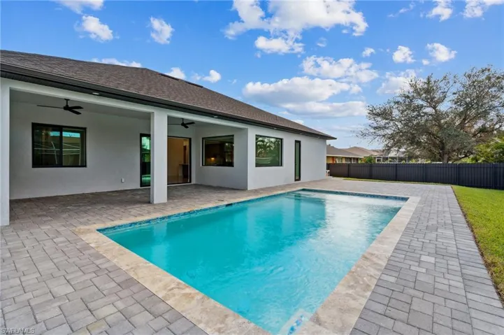 View of pool with a patio and ceiling fan