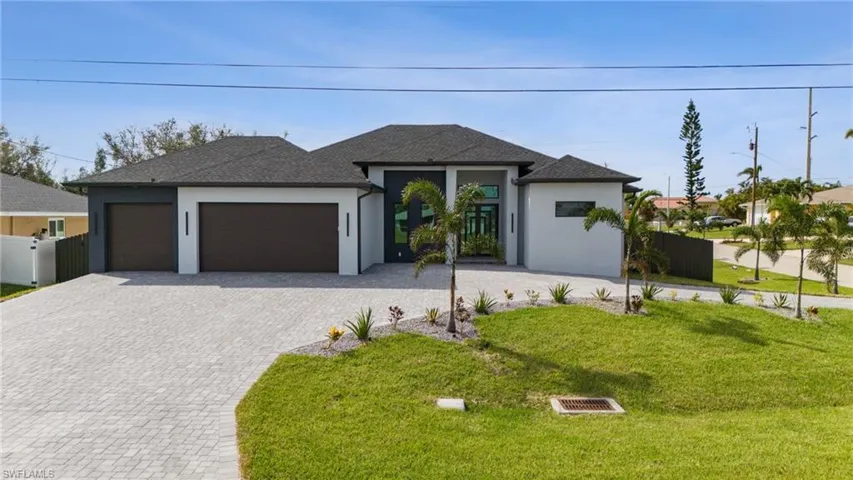 View of front of home with a front yard and a garage