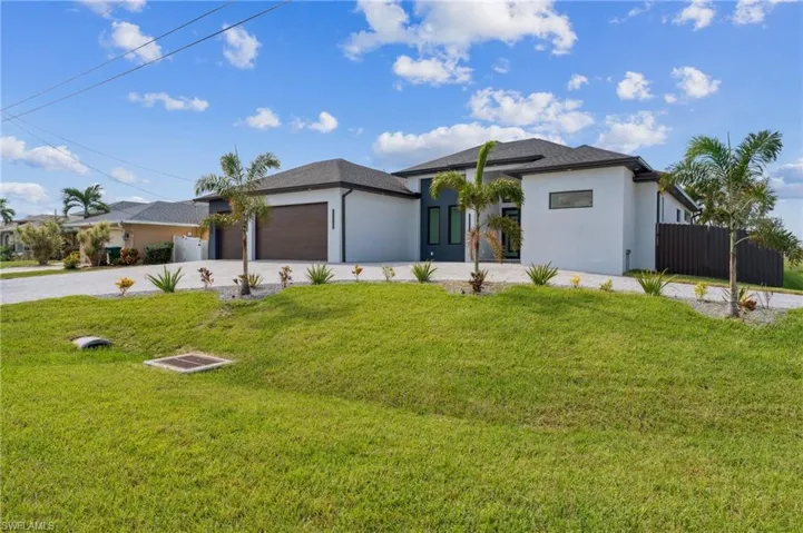 View of front facade featuring a front lawn and a garage
