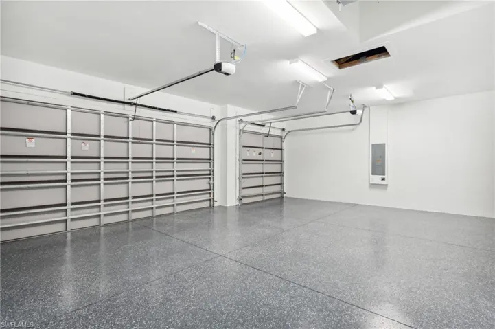 Garage featuring a garage door opener and electric panel