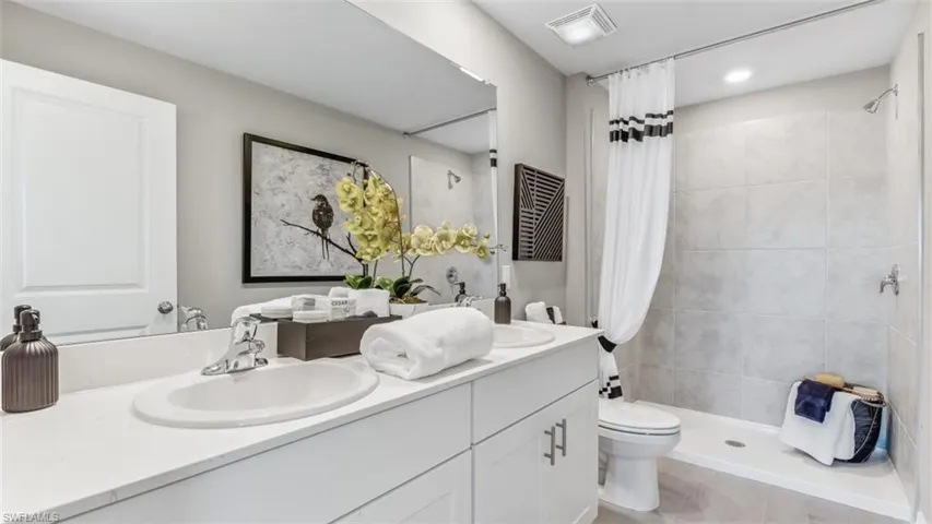 Bathroom with toilet, vanity, and walk in shower