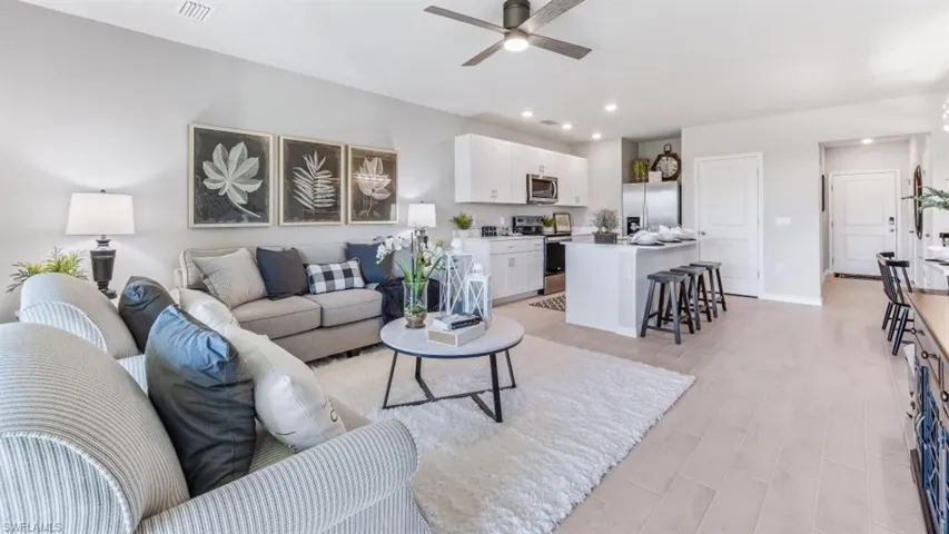 Living room with ceiling fan and light wood-type flooring