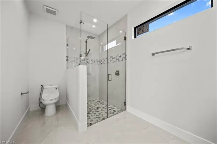 Full bath with baseboards, a marble finish shower, toilet, marble finish floors, and recessed lighting