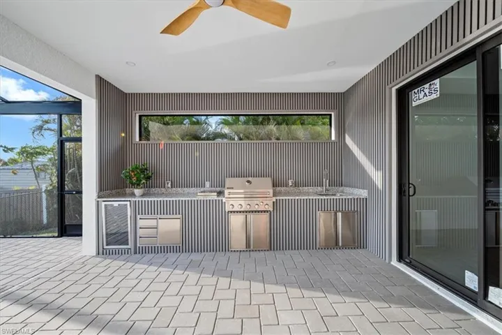 View of patio with wine cooler, a ceiling fan, and a sink