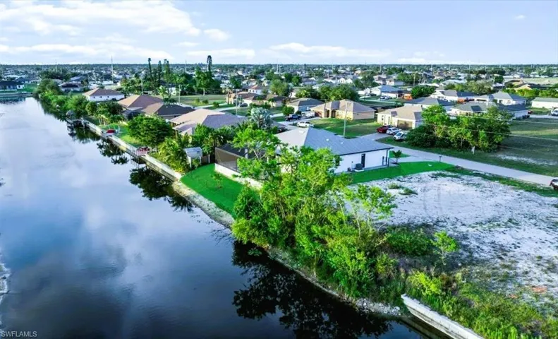 Aerial perspective of suburban area featuring a nearby body of water