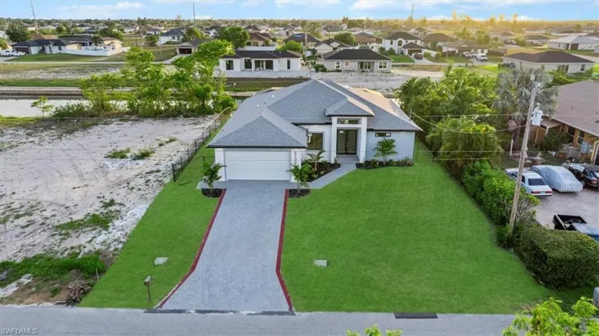 View of front facade featuring a residential view, driveway, a garage, and a front yard